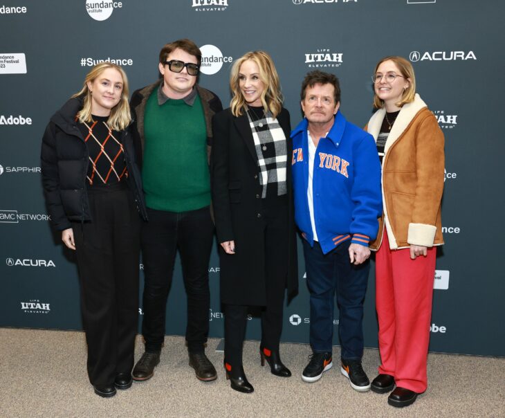 Michael J. Fox posando con su familia en la alfombra de un evento 