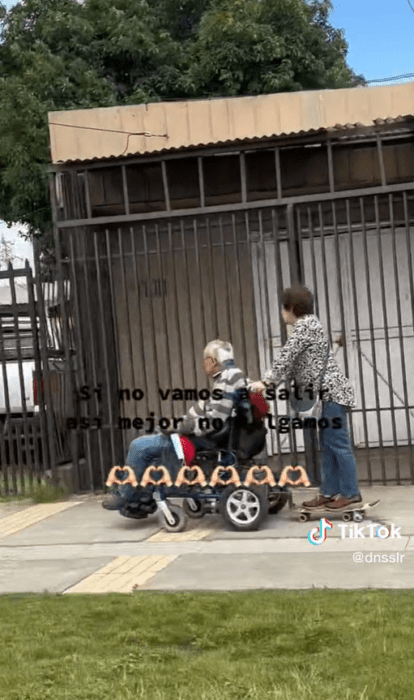 Pareja de abuelitos en silla de ruedas y patineta