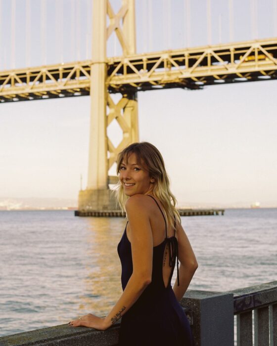 mujer en paisaje con puente atrás