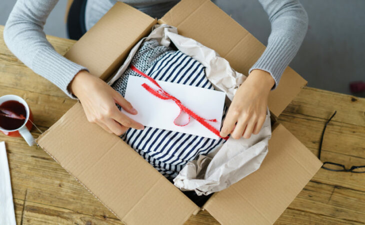 abriendo una caja de ropa con una nota