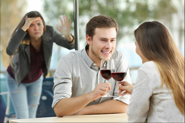 Hombre tomando una copa con una mujer y esposa descubriéndolo