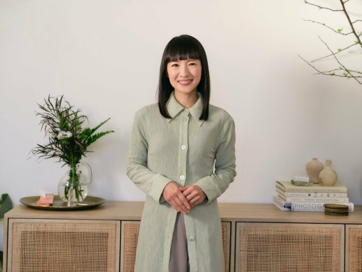 Marie Kondo con saco verde en ambiente ordenado 