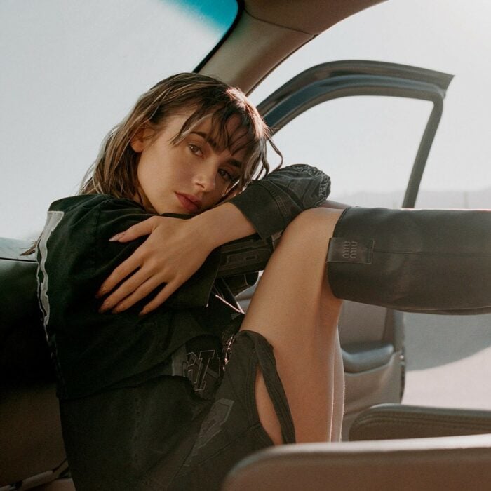 Lily Collins posando en el asiento de un carro durante una sesión de fotos 