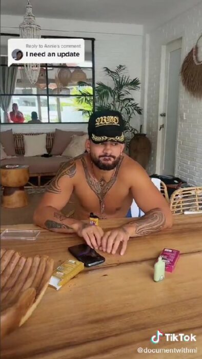 captura de pantalla de un chico sentado en la mesa de un lugar viendo hacia enfrente 
