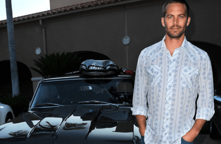 Paul Walker posando con un Porsche de color negro 