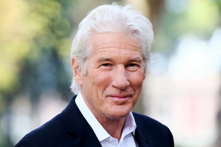 close-up image of Richard Gere wearing a dark jacket and white shirt his hair is completely white