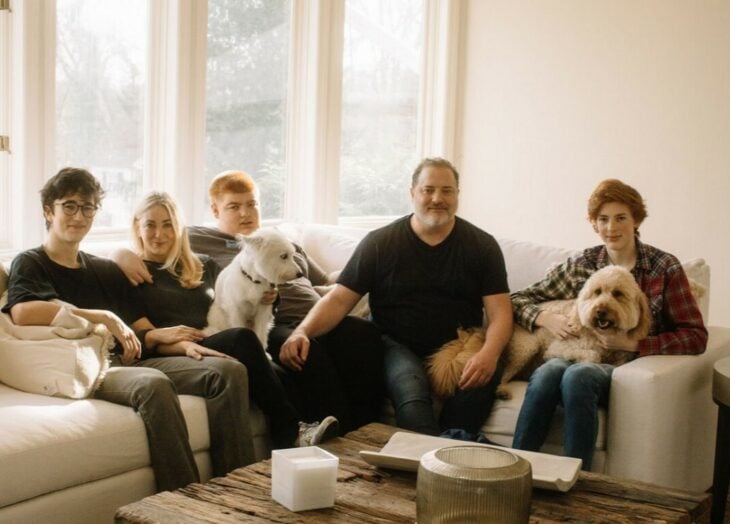 Brandan Fraiser sentando en la sala de su casa junto a sus hijos y mascota