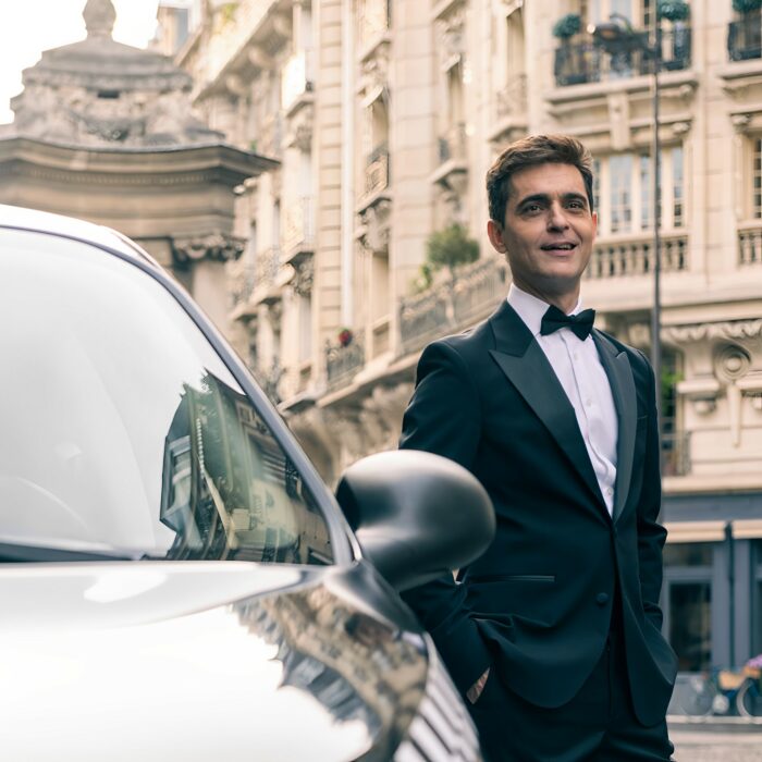 Pedro Alonso como Berlín posando en la calle a un lado de un carro