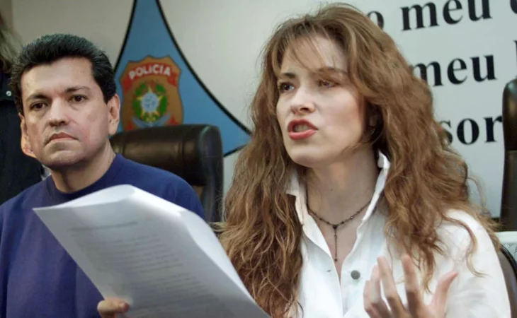 Gloria Trevi speaks with a document in hand while Sergio Andrade stays close to her