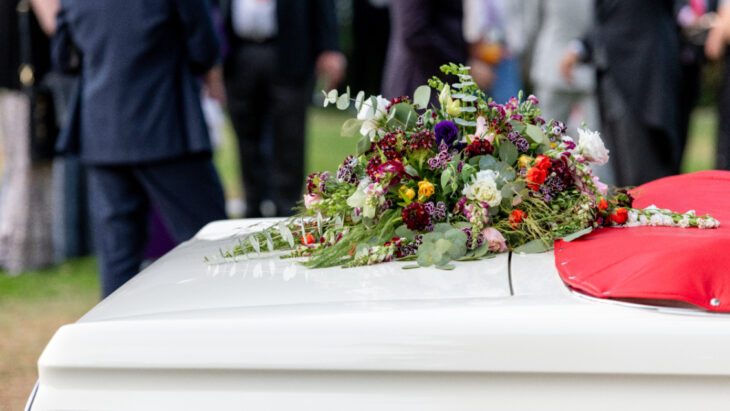 Funeral, féretro blanco con flores 