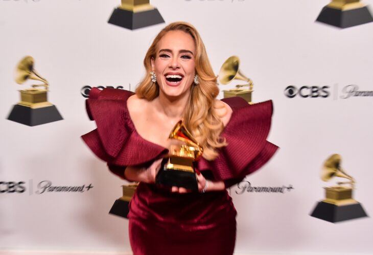 Adele posing with her Grammy Award for Best Pop Solo Performance