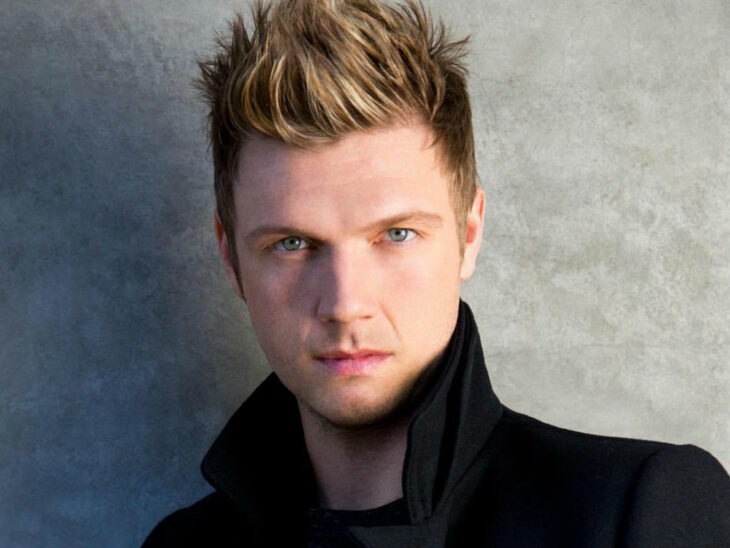 Nick Carter miembro de los Backstreet Boys posando para la cámara con un saco negro