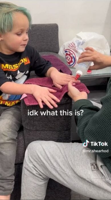 captura de pantalla de un niño que le están pintando las uñas de las manos 