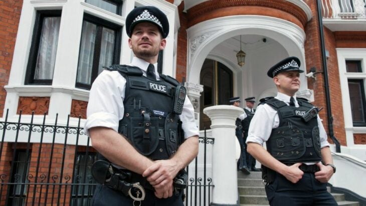 dos policías londinenses uniformados a las afueras de una residencia