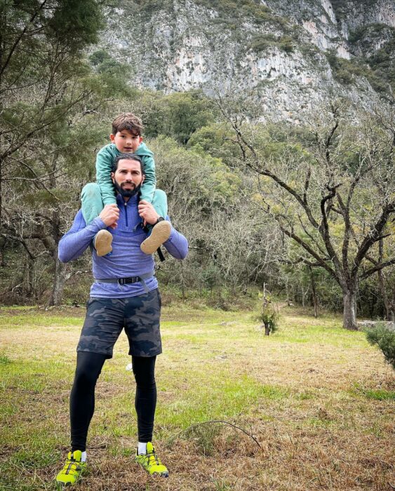 Fotografía de Poncho de Nigris cargando a su hijo en los hombros en unas montañas en la ciudad de Monterrey 