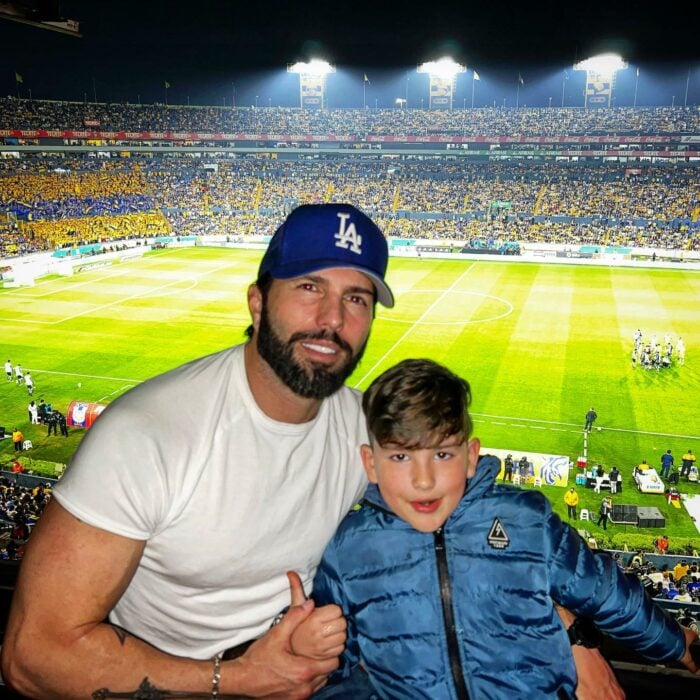 Fotografía de Poncho de Nigris posando al lado de su hijo Ponchito dentro del estadio de fútbol de los Tigres 