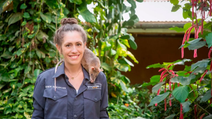 Donna Kean, investigadora del comportamiento y responsable del proyecto de entrenamiento de ratas para el rescate posa con una ratita en el hombro