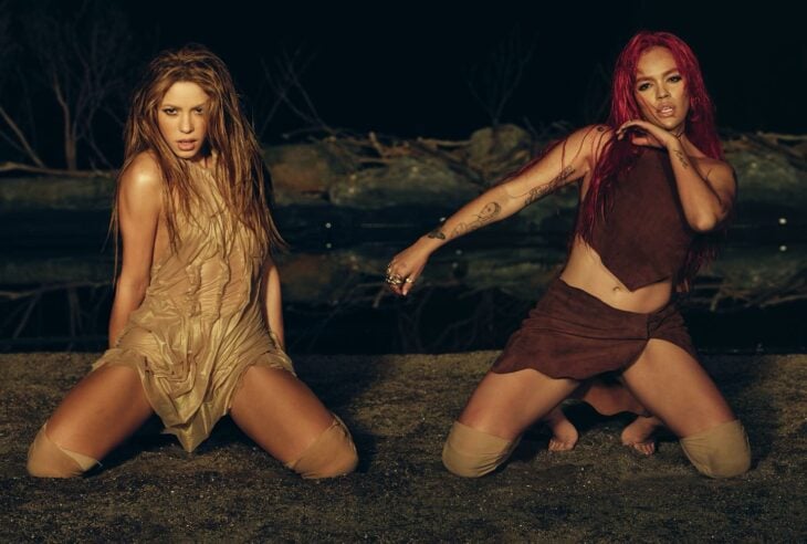Fotografía en la que aparecen Shakira junto a Karol G hincadas en el suelo en una pose sensual durante la grabación de su video musical Te quedó grande 