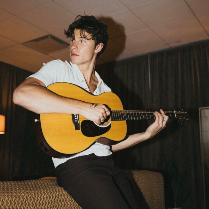 Shawn Mendes tocando la guitarra en lo que parece ser un estudio 