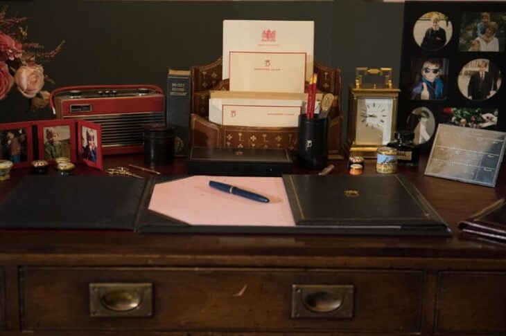imagen que muestra una mesa con algunas cartas y fotos de la realeza 