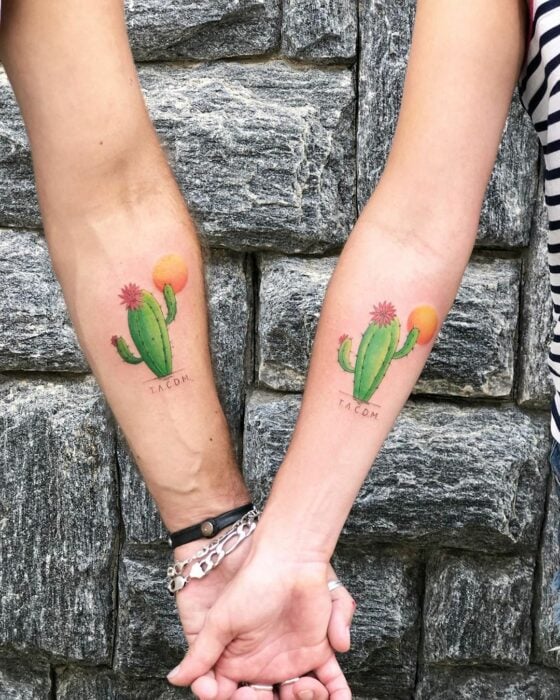 dos personas mostrando un tatuaje de cactus en sus antebrazos 