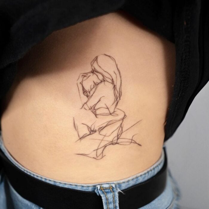 torso de una persona mostrando el diseño de tatuaje de dos personas abrazadas 