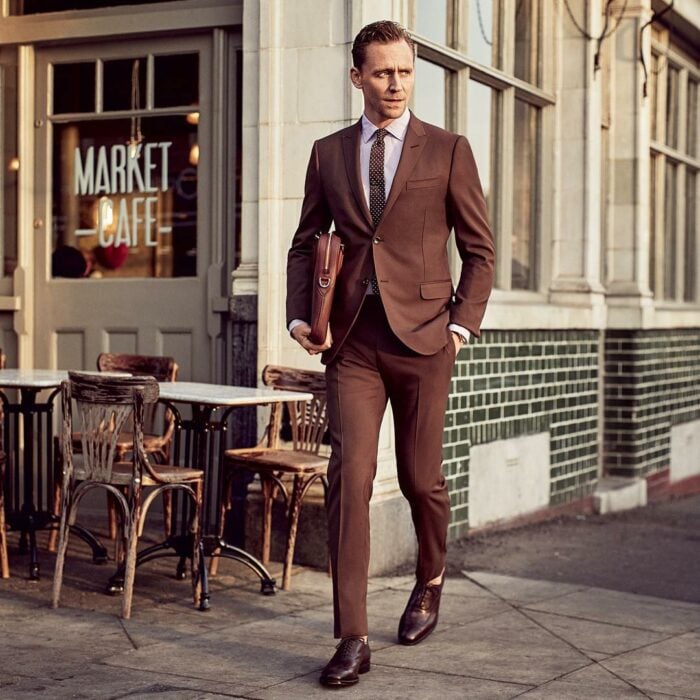 Tom Hiddleston caminando por la calle de traje 