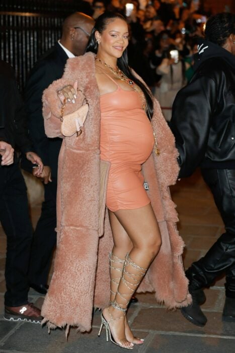 Rihanna posando con un vestido de cuero color naranja a juego con un saco de mink calientito 