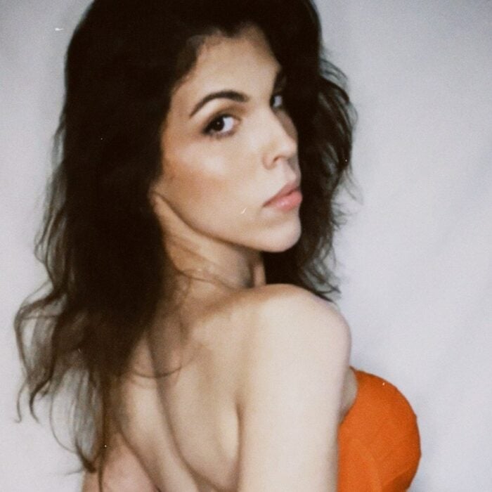 Daniela Arroyo de espaldas con top naranja