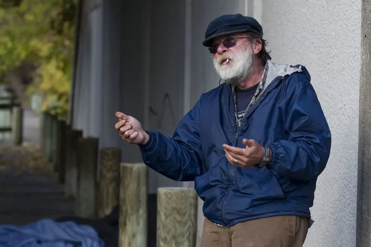 Anthony Ciccone fumando un cigarrillo y pidiendo dinero en la calle