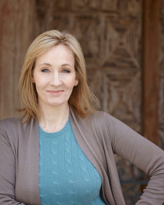 jk rowling con blazer gris y suéter azul 