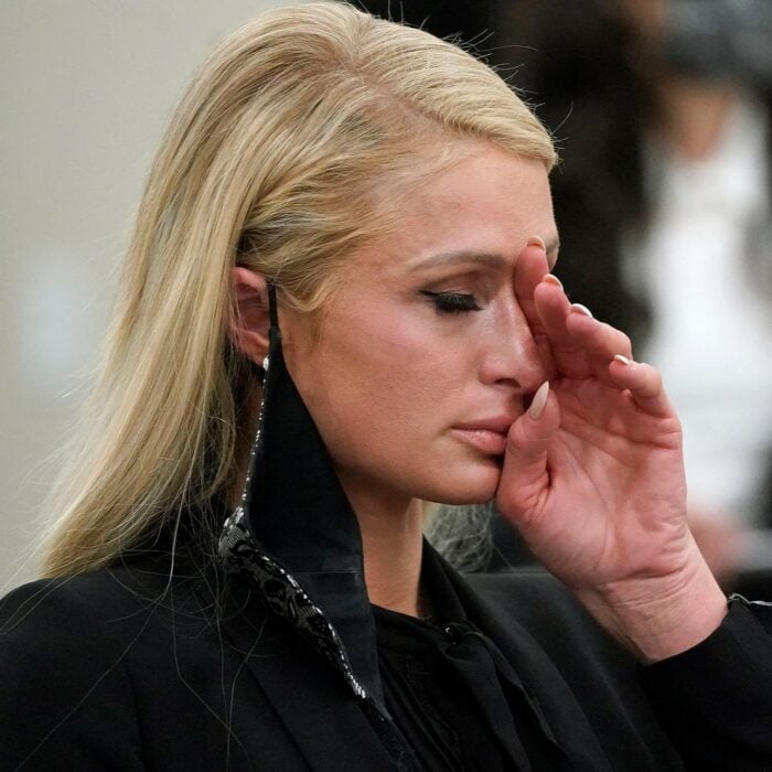 Paris Hilton llorando con su mano cubriendo parte de su rostro