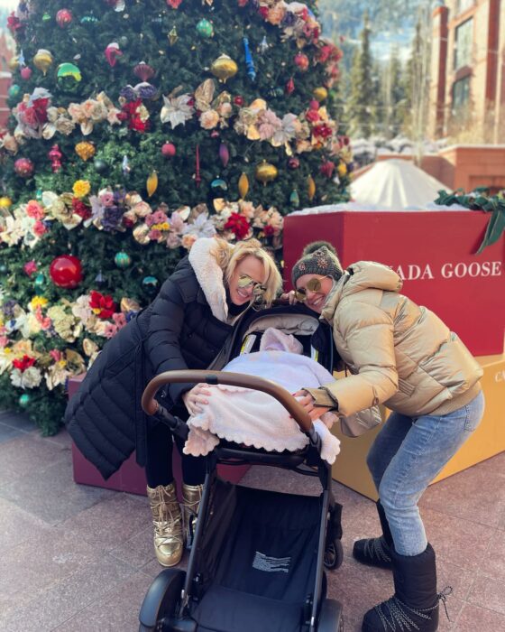 rebel wilson su bebé y su novia frente al árbol de navidad