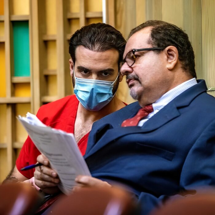 Pablo Lyle leyendo un documento justo a su abogado Phill Reitzenstein 