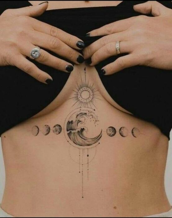 tatuaje con el diseño de luna entre los pechos de una mujer 