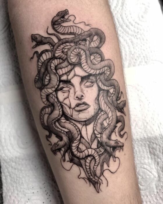 Brazo mostrando un tatuaje de mujer con cabeza de medusa hecha de serpientes
