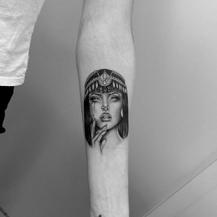 brazo de una persona mostrando un tatuaje con la cara de la reina Cleopatra 
