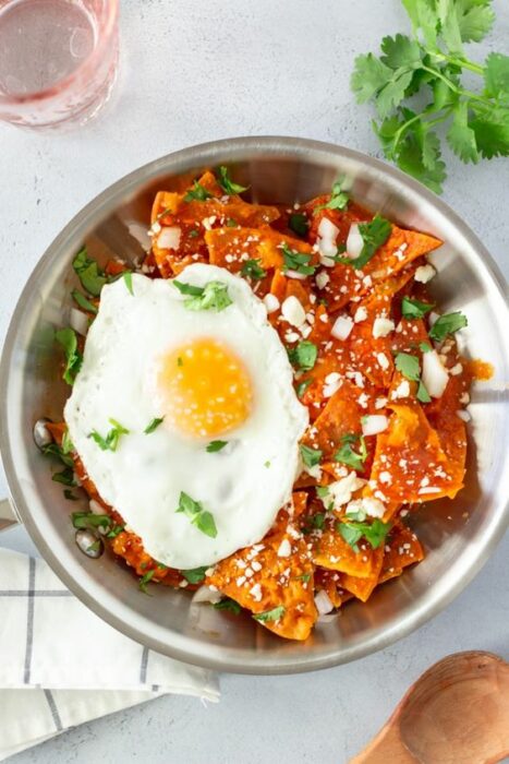 chilaquiles rojos con un huevo estrellado en un bowl