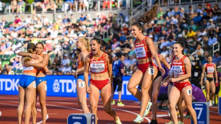 Mujeres atletas celebrando sobre la pista después de competencia