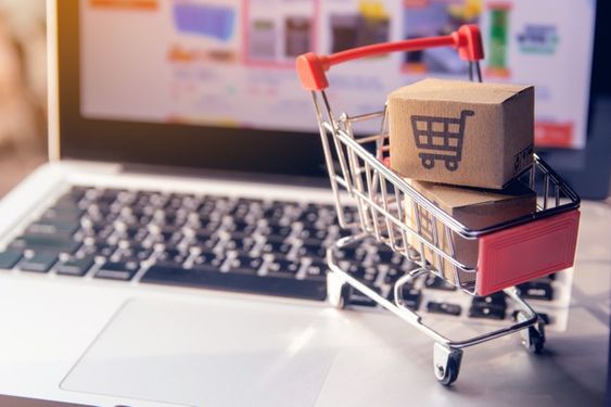 compras en internet con un carrito pequeño arriba de una computadora