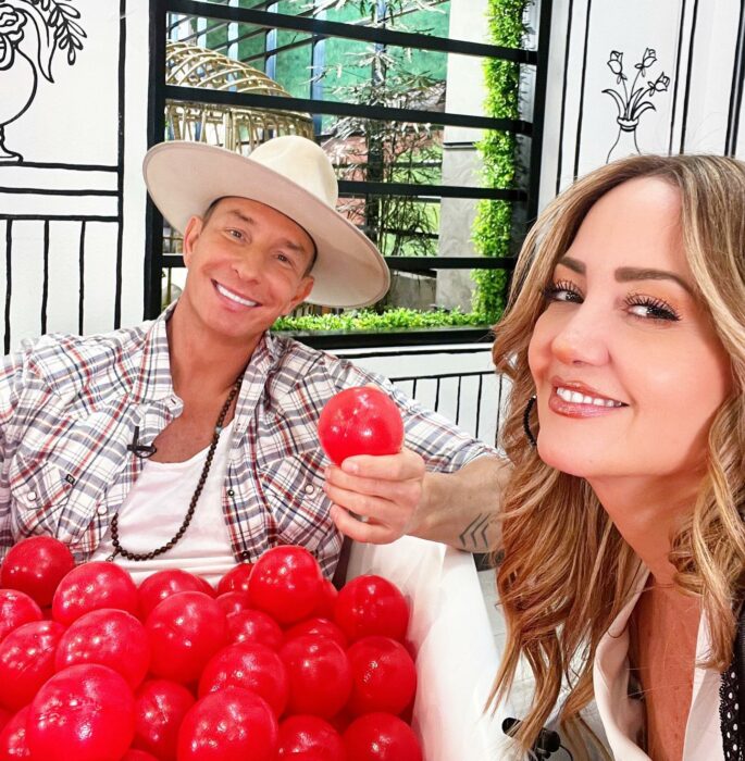 selfie que muestra a Andrea Legarreta junto a Erik Rubín rodeados de algunas pelotas de plástico en color rojo 