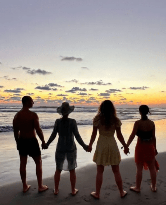 la familia Rubí Legarreta en una imagen en la playa todos están de espaldas a la foto viendo de frente el mar en un atardecer tomados de las manos