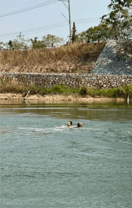 un par de hombres están sumergidos en un lago sólo se ven sus cabezas