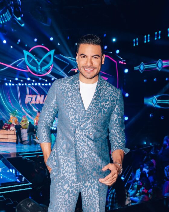 Fotografía de Carlos Rivera posando con el escenario de el programa La Máscara de fondo 