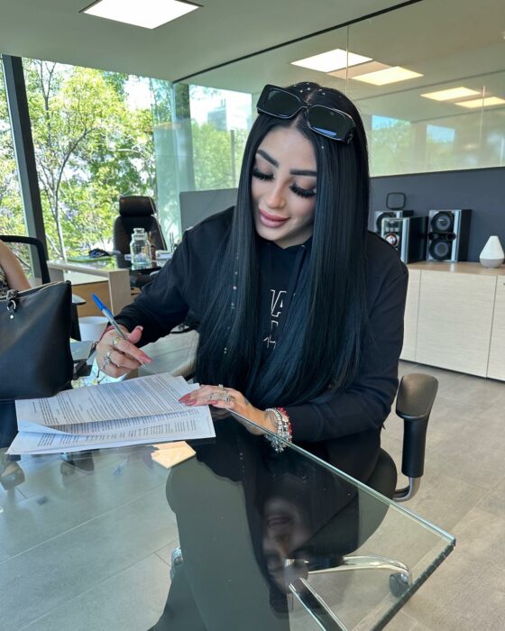 Photograph of the singer Bellakath signing some documents at the Society of Authors and Composers of Mexico