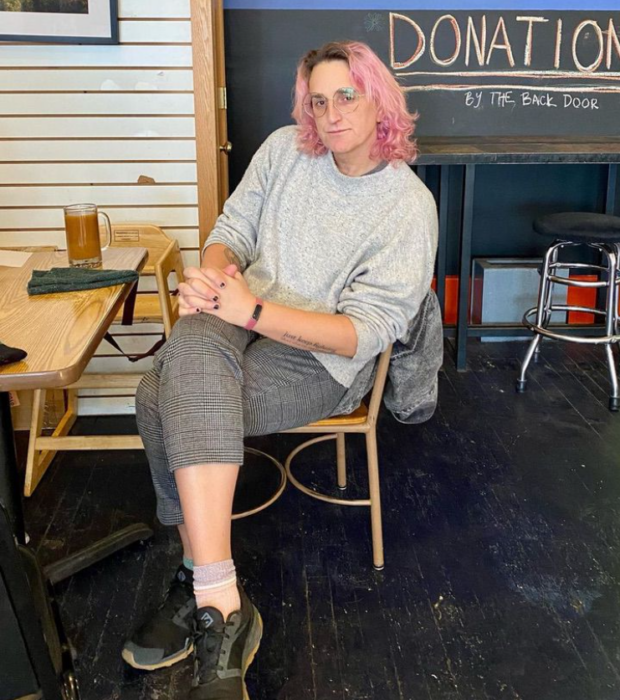 Leigh Finke, persona trans que trabaja legislando en Estados Unidos, sentada en una silla junto a un escritorio de madera