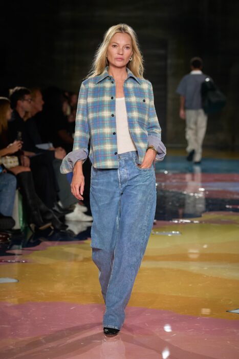 Kate Moss posando en jeans y camisa de cuadros en una pasarela 