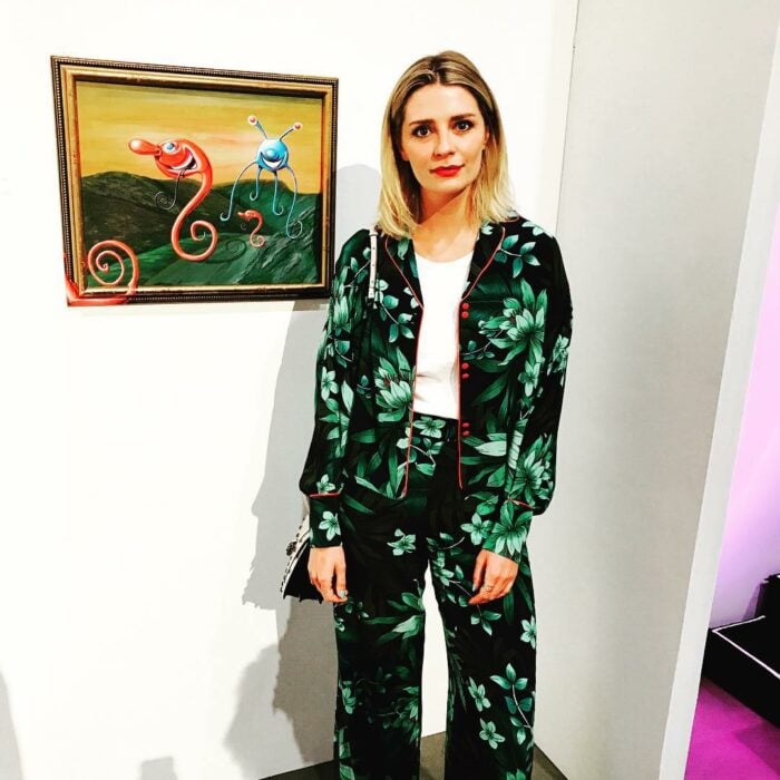 Mischa Barton posando con un conjunto en color verde frente a una pintura famosa 