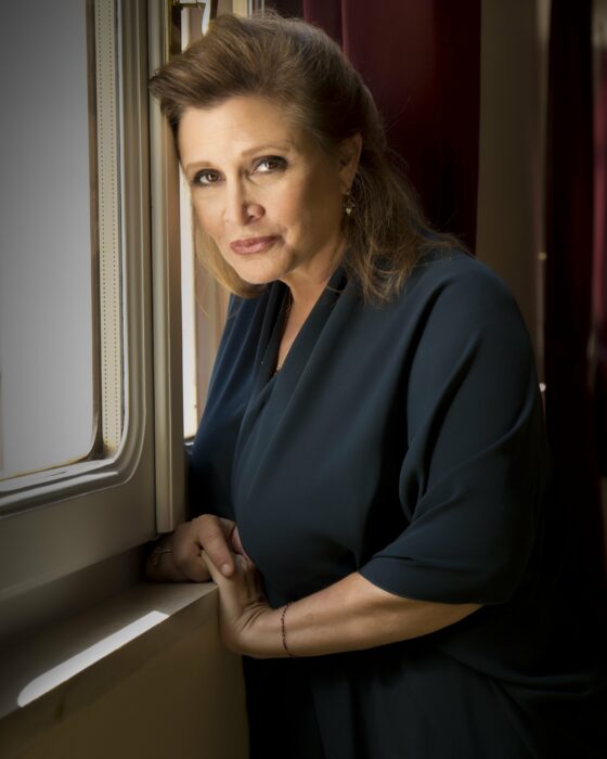 Imagen que muestra a Carrie Fisher posando recargada en una ventana 