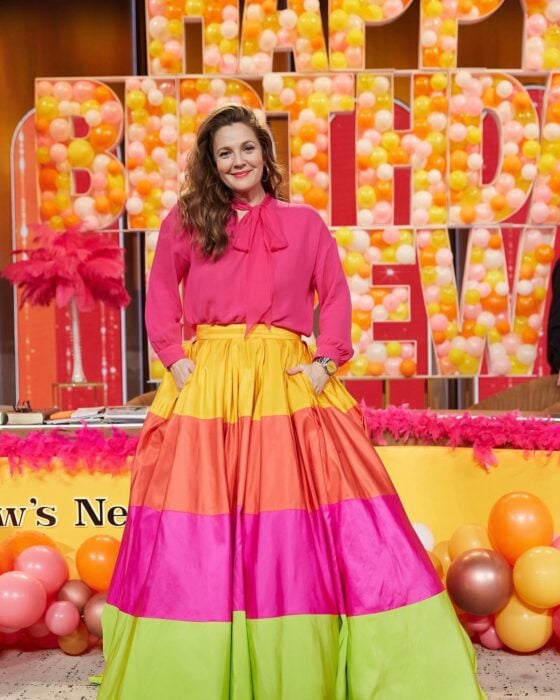  Drew Barrymore posando con un vestido de colores sobre un letrero hecho con globos 
